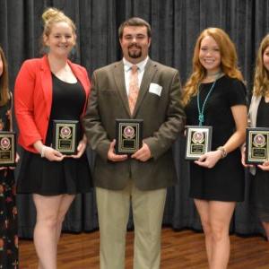 Students holding plaques